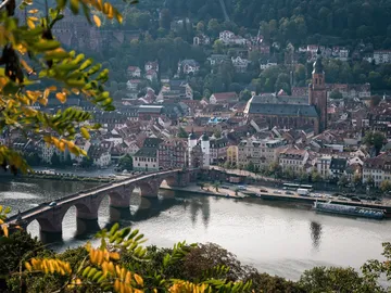 Stadtansicht mit Brücke, Fluss und historischen Gebäuden.